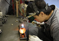 ベリアルの工場では各種工作機械を備え、一部のパーツを除き開発から製造まで自社で一貫して行える体勢を整えている。工場内には、金属加工用の大型機材や、溶接機などがズラリと並べられている。その中で目立つのが、マフラーやチャンバーの製作に使用される治具類。治具は、それぞれの商品に合わせた専用品が必要。オーダーメードで造られる、治具の製作には当然コストもかかるのだが、精度が高く品質が均一な製品造りには欠かせないものだ。パーツ製作に携わるスタッフは、皆熟練した職人ばかり。各々が高い技術を持ち、また、品質向上に向けた高いモラルが感じられる製造現場だ。 